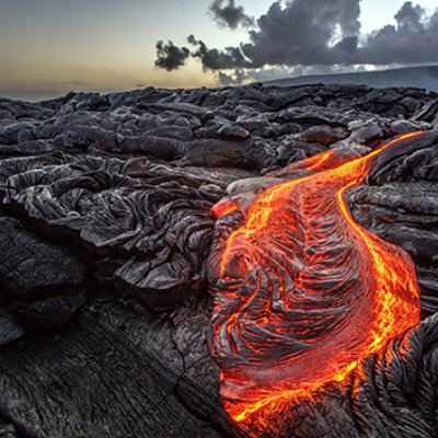 Molten lava spilling over volcanic rocks 